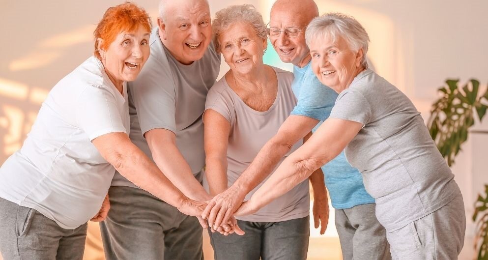 Five older people joining hands