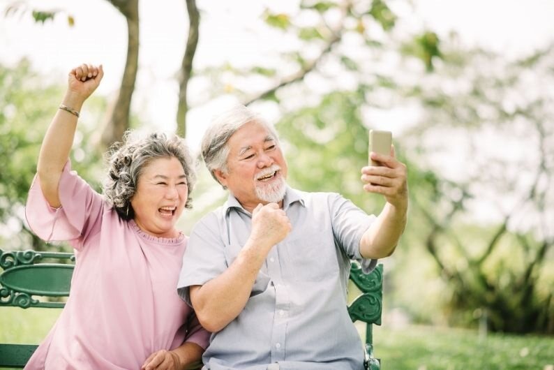 Older couple posing for a selfie and laughing