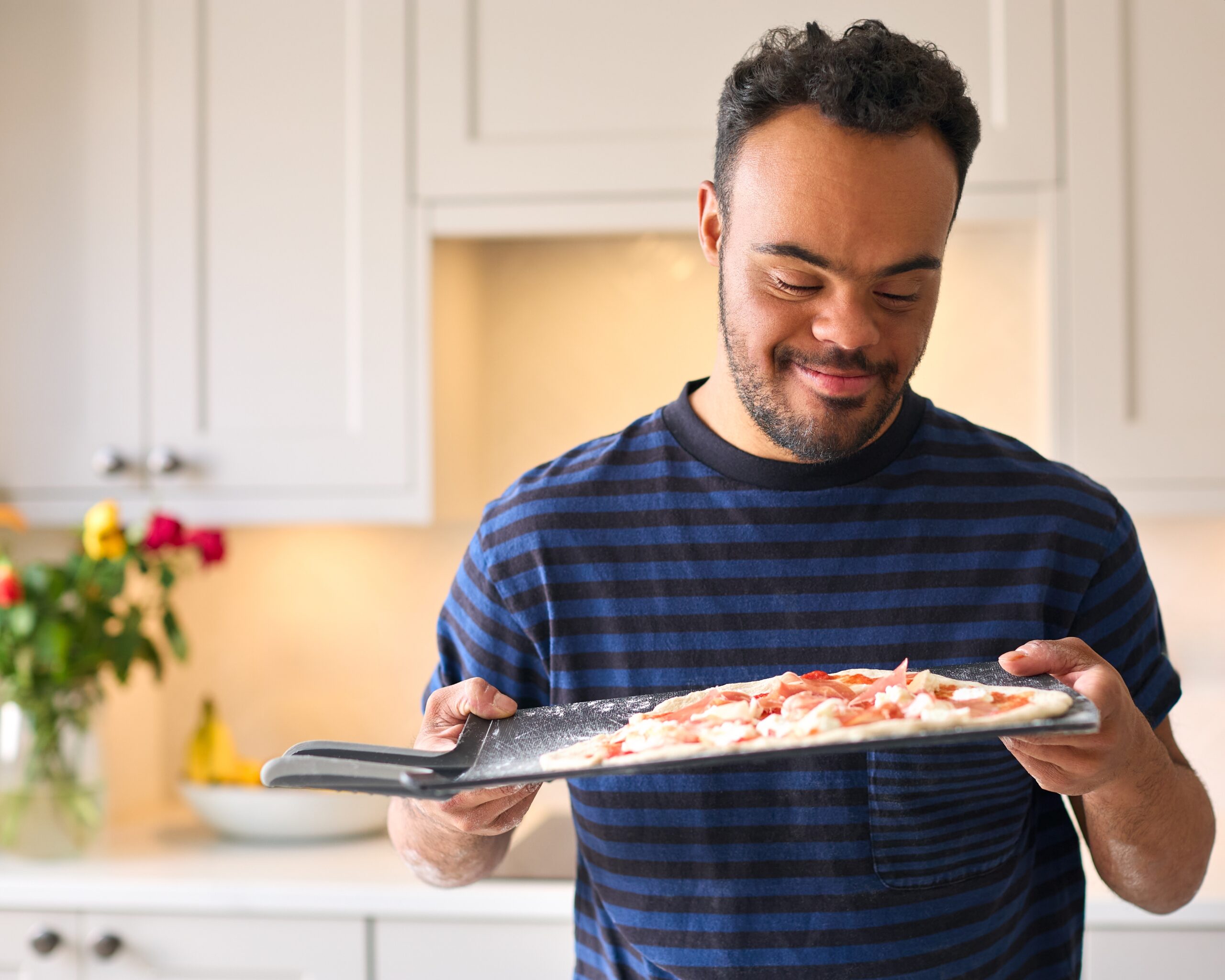 man with down syndrome making pizza